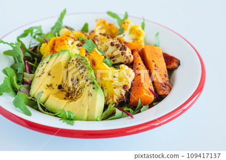 Warm winter salad with roasted cauliflower, sweet potato and avocado. 109417137
