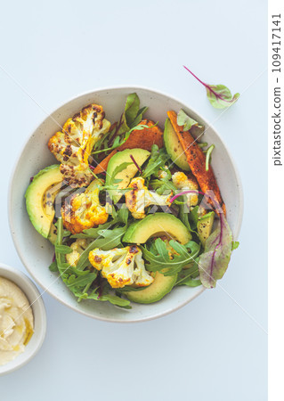 Warm winter salad with roasted cauliflower, sweet potatoes and avocado. 109417141