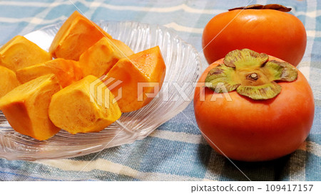 切好的柿子放在玻璃盤上，還有兩個飽滿的柿子。山梨縣名牌冬柿、廣瀨柿 109417157