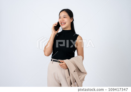A confident Asian businesswoman or female boss is talking on the phone, isolated white background. A confident Asian businesswoman or female boss is talking on the phone, isolated white background. 109417347