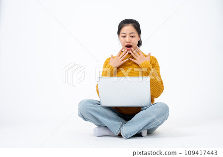 Excited woman looking at her laptop screen with a shocking face, surprised with an unexpected news. 109417443