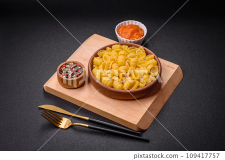 Raw durum wheat gnocchi pasta with salt and spices in a ceramic plate Raw durum wheat gnocchi pasta with salt and spices in a ceramic plate 109417757