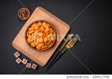 Delicious fresh pasta with pesto sauce, salt, spices and herbs on a ceramic plate Delicious fresh pasta with pesto sauce, salt, spices and herbs on a ceramic plate 109417796