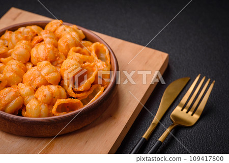 Delicious fresh pasta with pesto sauce, salt, spices and herbs on a ceramic plate 109417800