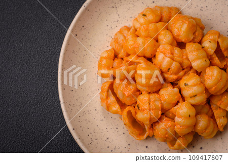 Delicious fresh pasta with pesto sauce, salt, spices and herbs on a ceramic plate 109417807