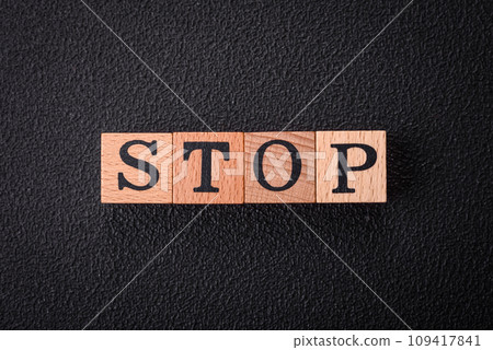 The inscription stop on wooden cubes on a dark concrete background 109417841