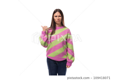 young caucasian woman with black hair dressed in a pink striped sweater points with her hand on a young caucasian woman with black hair dressed in a pink striped sweater points with her hand on a 109418071