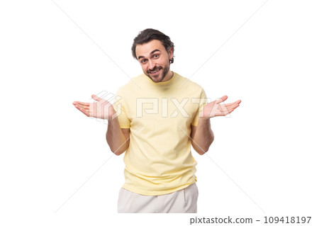 caucasian smart brutal charming guy with a beard dressed in a summer t-shirt spreads his arms 109418197