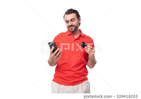 a young brutal 35 year old european man with a well-groomed haircut and a beard in a red t-shirt 109418203