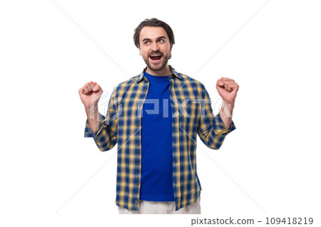 happy brunette brutal man with a beard in a plaid shirt rejoices in good luck happy brunette brutal man with a beard in a plaid shirt rejoices in good luck 109418219
