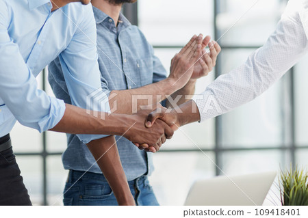 Successful Business Collaboration: Executives Greet with Handshake in Office 109418401