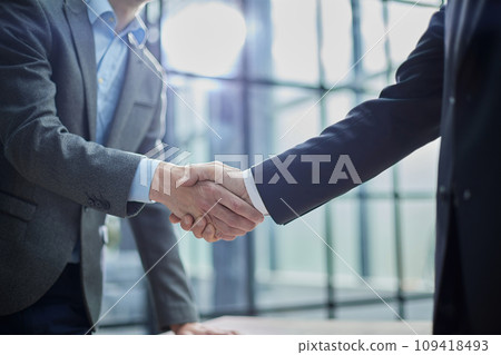 Two diverse professional business men executive leaders shaking hands at office meeting Two diverse professional business men executive leaders shaking hands at office meeting 109418493