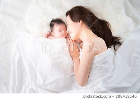 A mother co-sleeping with her one-month-old son A mother co-sleeping with her one-month-old son 109419146