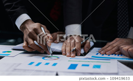 business colleagues look at the graph on the table from above business colleagues look at the graph on the table from above 109419633