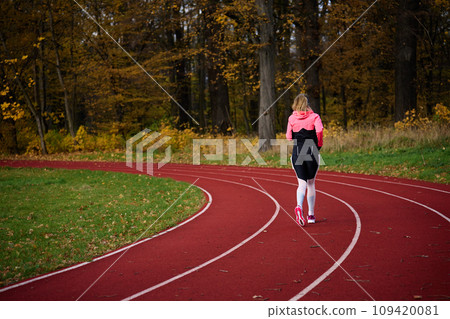 Woman running at stadium track 109420081