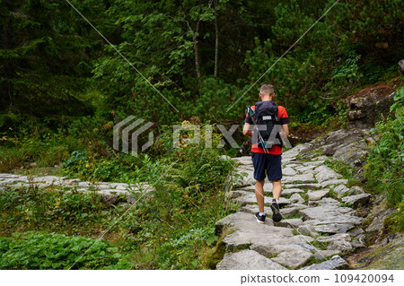 Man hiking in forest with backpack 109420094