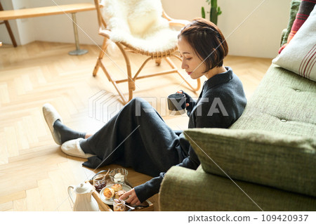 A woman slowly drinking tea A woman slowly drinking tea 109420937