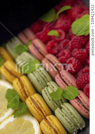macaroons of different colors with with raspberries, lemon and mint macaroons of different colors with with raspberries, lemon and mint 109421422