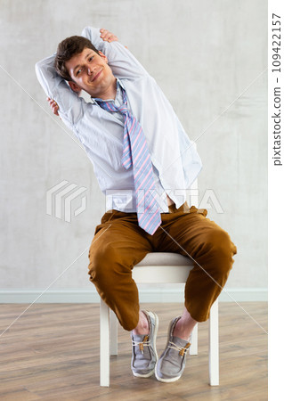 Young guy office worker doing exercises on chair Young guy office worker doing exercises on chair 109422157