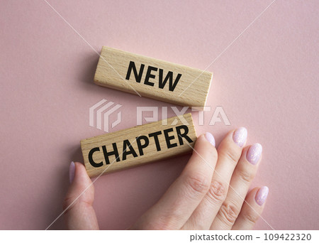 New Chapter symbol. Concept word New Chapter on wooden blocks. Businessman hand. Beautiful pink background. Business and New Chapter concept. Copy space 109422320