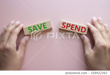 Save or Spend symbol. Concept word Save or Spend on wooden blocks. Businessman hand. Beautiful pink background. Business and Save or Spend concept. Copy space 109422362
