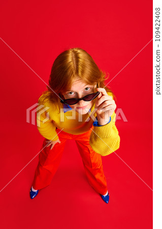 Top view. Close up portrait of young attractive business lady dressed retro style outfit posing against vivid red background. Concept of bright colors in fashion. 109422408