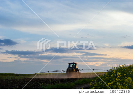 Tractor spraying pesticides on vegetable field with sprayer at spring Tractor spraying pesticides on vegetable field with sprayer at spring 109422586