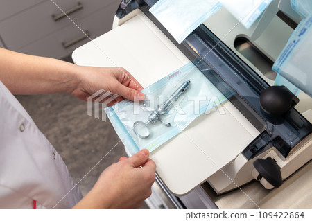 A medical worker packs steam sterilized medical instruments into special sleeves. A medical worker packs steam sterilized medical instruments into special sleeves. 109422864