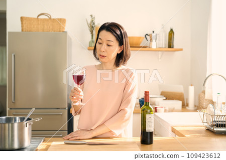 一個女人在廚房裡喝葡萄酒 一個女人在廚房裡喝葡萄酒 109423612