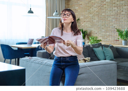 Middle-aged woman feeling pre-menopausal symptoms, hot flush, at home Middle-aged woman feeling pre-menopausal symptoms, hot flush, at home 109423688