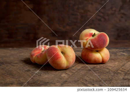 Several saturn peaches or flat peaches on wooden background.. Several saturn peaches or flat peaches on wooden background.. 109425634