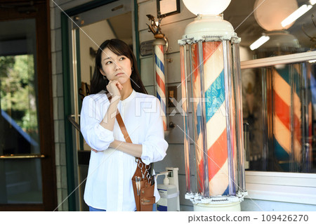 Asian female barber worried in front of the barber shop 109426270