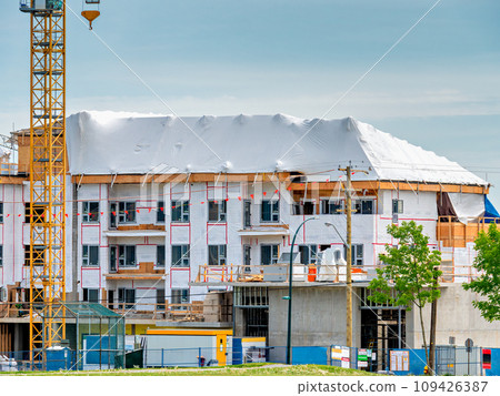 New low-rise residential building under construction on blue sky background New low-rise residential building under construction on blue sky background 109426387