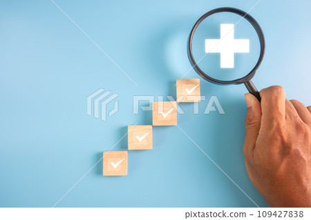 Magnifier and Wooden block with medical icon for medical healthcare check and health insurance concept 109427838