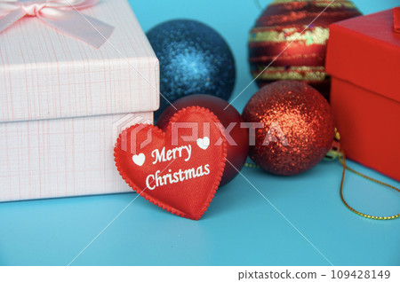 Merry Christmas text on heart shape with Christmas presents and decoration. 109428149