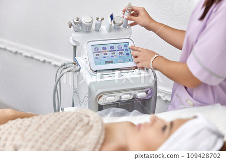 beautician using cosmetology equipment in modern aesthetic clinic. beautician using cosmetology equipment in modern aesthetic clinic. 109428702