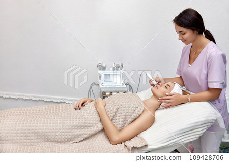cosmetologist making procedure microdermabrasion on the face in beauty salon 109428706