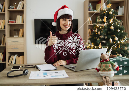 Caucasian businesswoman in Santa hat looking at camera Caucasian businesswoman in Santa hat looking at camera 109428750