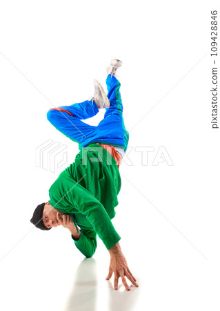 Air twist. Young athletic man, b-boy dancing hip-hop, breakdance on hands raising legs up in motion against white background. Air twist. Young athletic man, b-boy dancing hip-hop, breakdance on hands raising legs up in motion against white background. 109428846