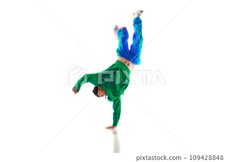 Fashionable portrait. Stylishly dressed man dancing in freestyle, breakdance style in motion against white studio background. 109428848