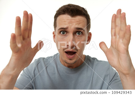 surprised guy looking at camera on white studio background surprised guy looking at camera on white studio background 109429343