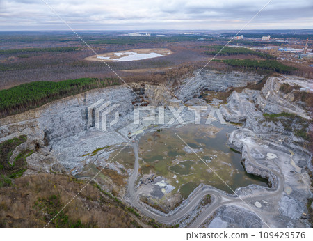 Stone quarry in the forest. Flying over the autumn mixed forest during sunset. The surroundings of Yekaterinburg. Ural, Russia, Aerial View 109429576