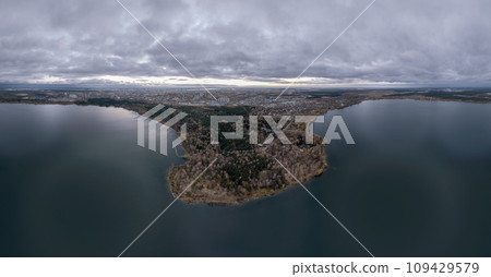Autumn forest on lake shore at sunset and city on horizon, aerial view Autumn forest on lake shore at sunset and city on horizon, aerial view 109429579