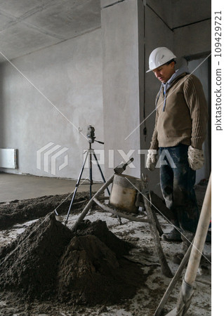 A builder in work clothes is doing his job 109429721