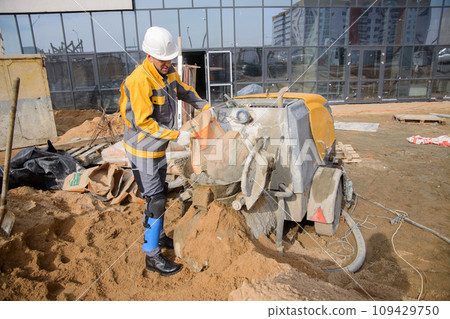 A builder in work clothes is  doing his job 109429750