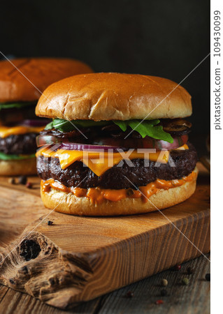 Two delicious homemade burgers of beef, cheese and mushrooms on an wooden table. Fat unhealthy food 109430099