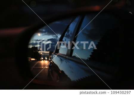 Car reflected in the side mirror in the sunset Car reflected in the side mirror in the sunset 109430297