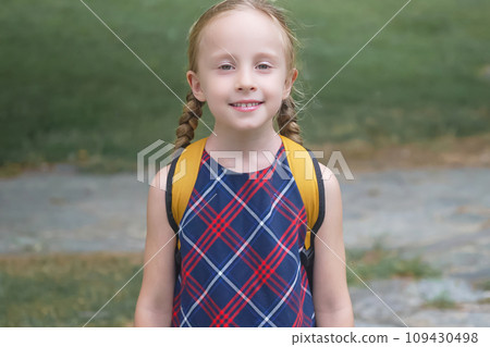 Beaming blonde schoolgirl with a yellow backpack, radiating joy on her way to school, Back to school concept 109430498