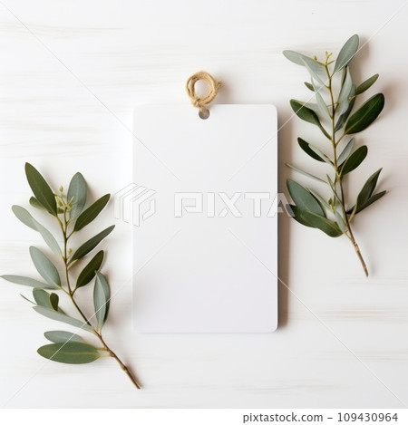 white blank tag with blank front realistic on a mockup template in a white wooden table with olive leaf branch white blank tag with blank front realistic on a mockup template in a white wooden table with olive leaf branch 109430964