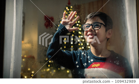 Child greeting to Santa through the window 109432989
